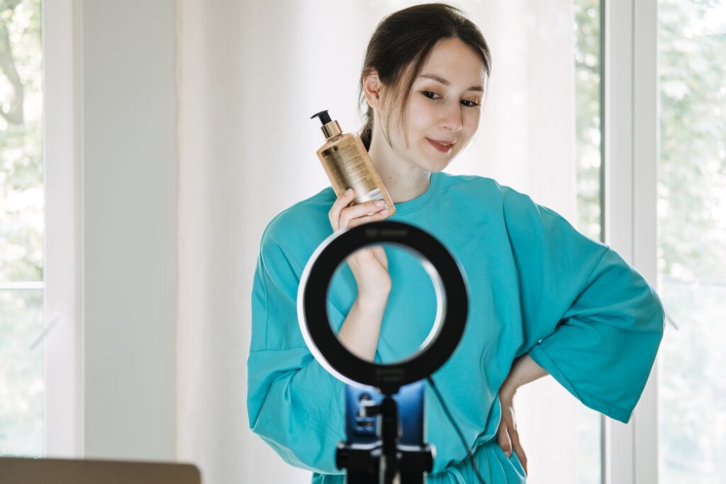 Beauty influencer demonstrating skincare product with ring light setup, content creation, social